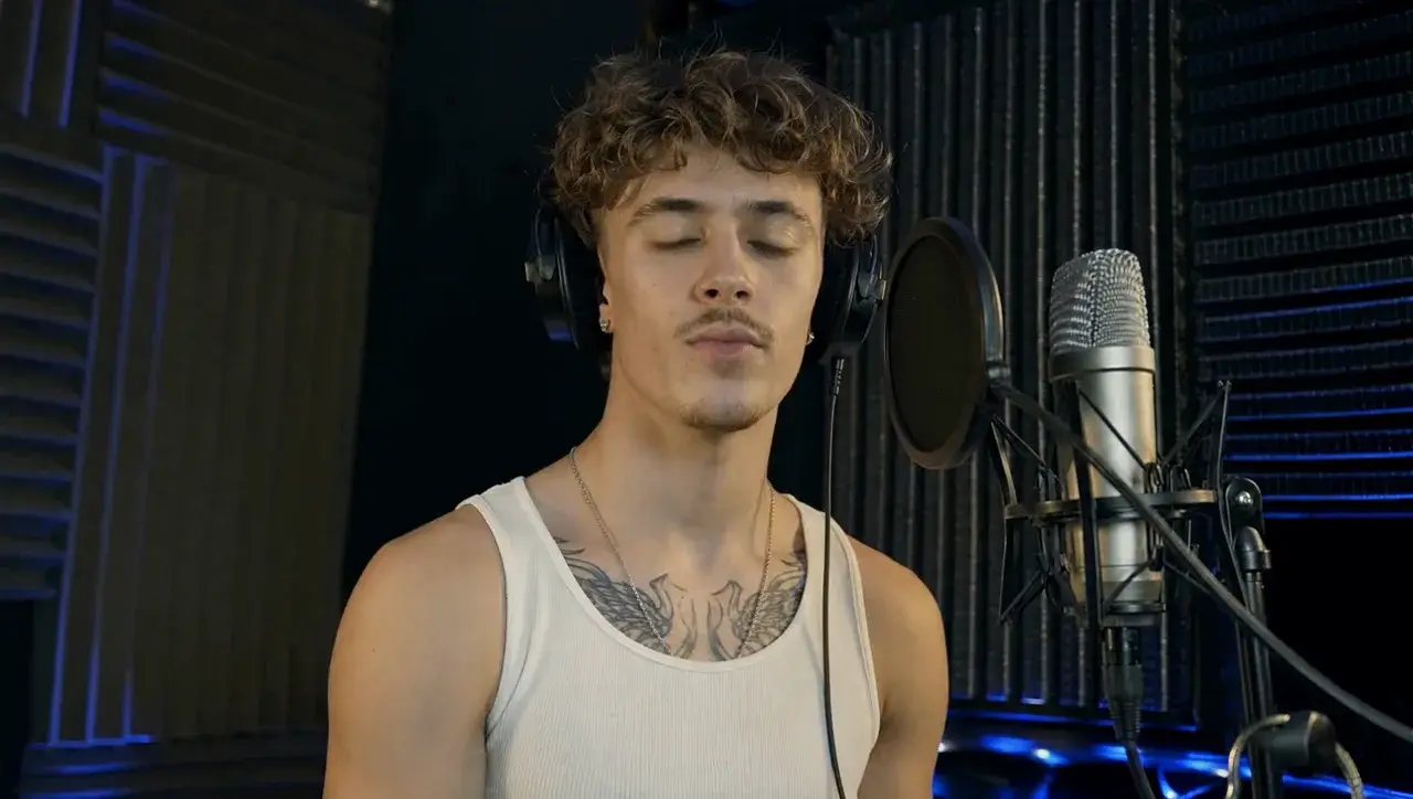 A singer in headphones records at a studio microphone.