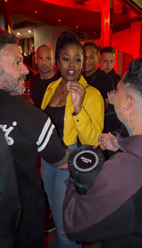 Lead in a yellow jacket freestyling behind the speaker holder